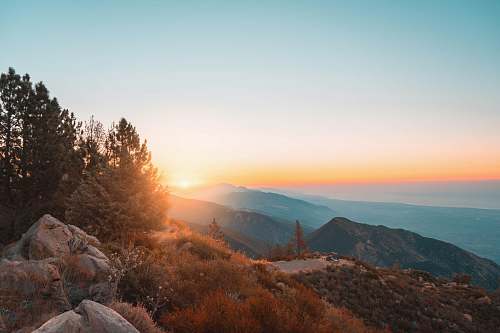 la cumbre peak stones on grass field near trees during golden hour brown